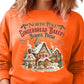 Bright orange sweatshirt with gingerbread house design, bringing holiday cheer.