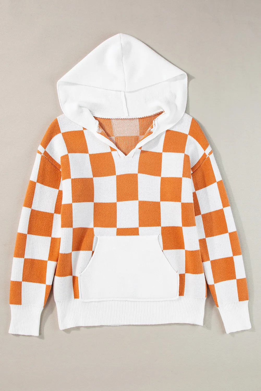 Orange and white checkered sweater with a hood, featuring a front pocket and long sleeves.
