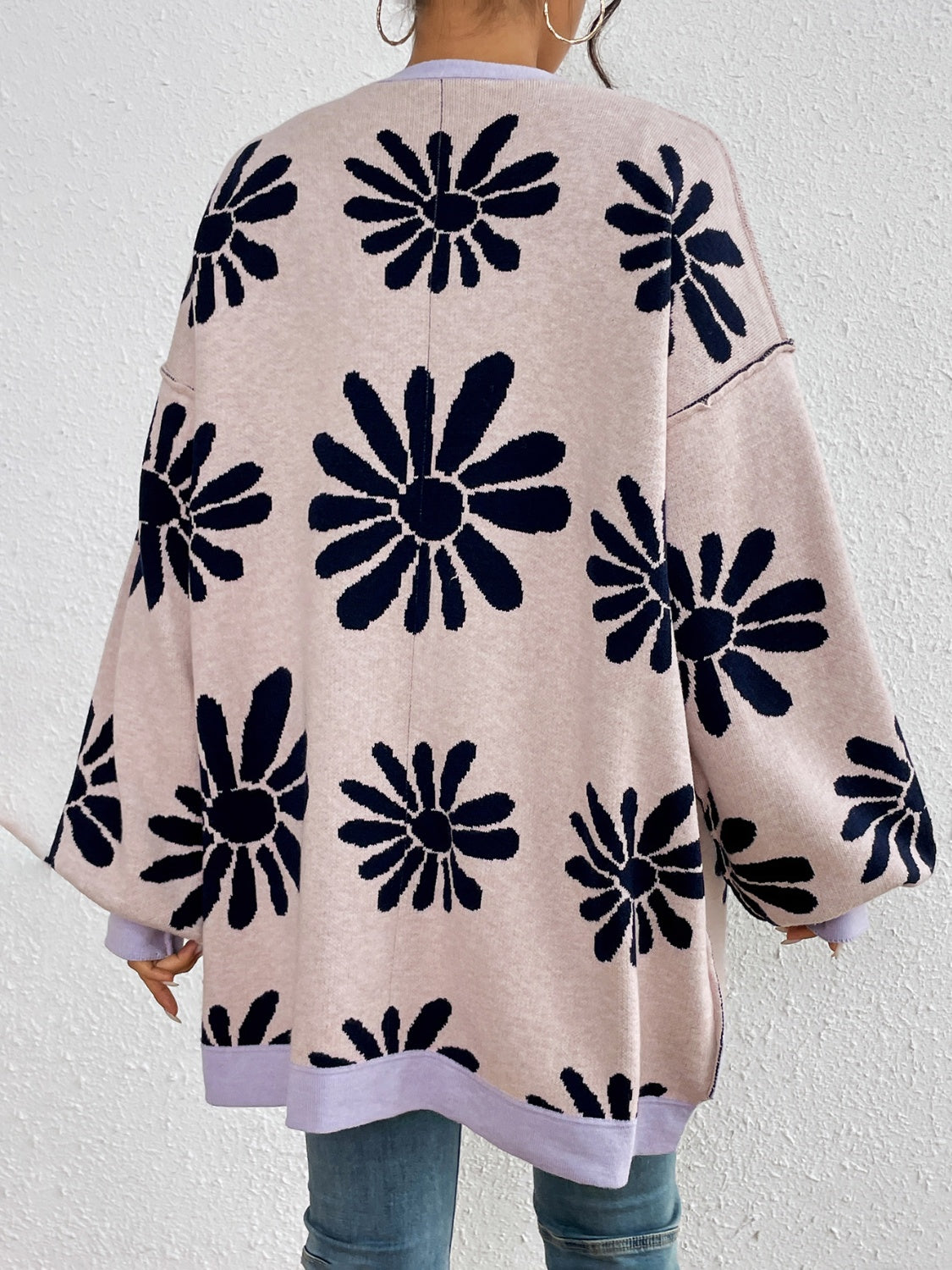 Pink oversized cardigan with large navy flower prints and button-up detail.
