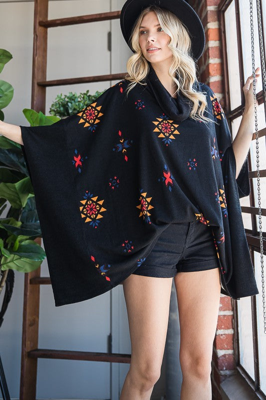 Relaxed-fit black poncho with vibrant Aztec motifs and a cowl neck.