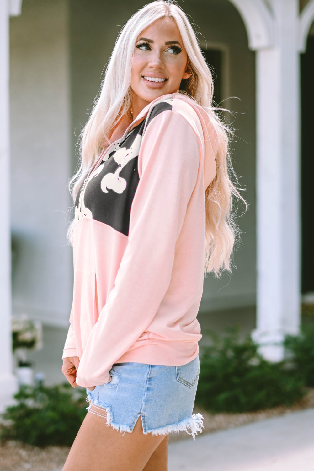 Lightweight pink pullover with cow print design and front pocket
