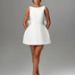 Chic white formal dress featuring pearl embellishments and bow detail

