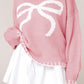 Front view of a pink bow-knot knit sweater, adding a playful element to your cozy winter outfits.