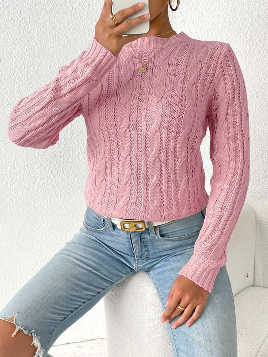 Woman in a pink cable knit sweater paired with casual denim