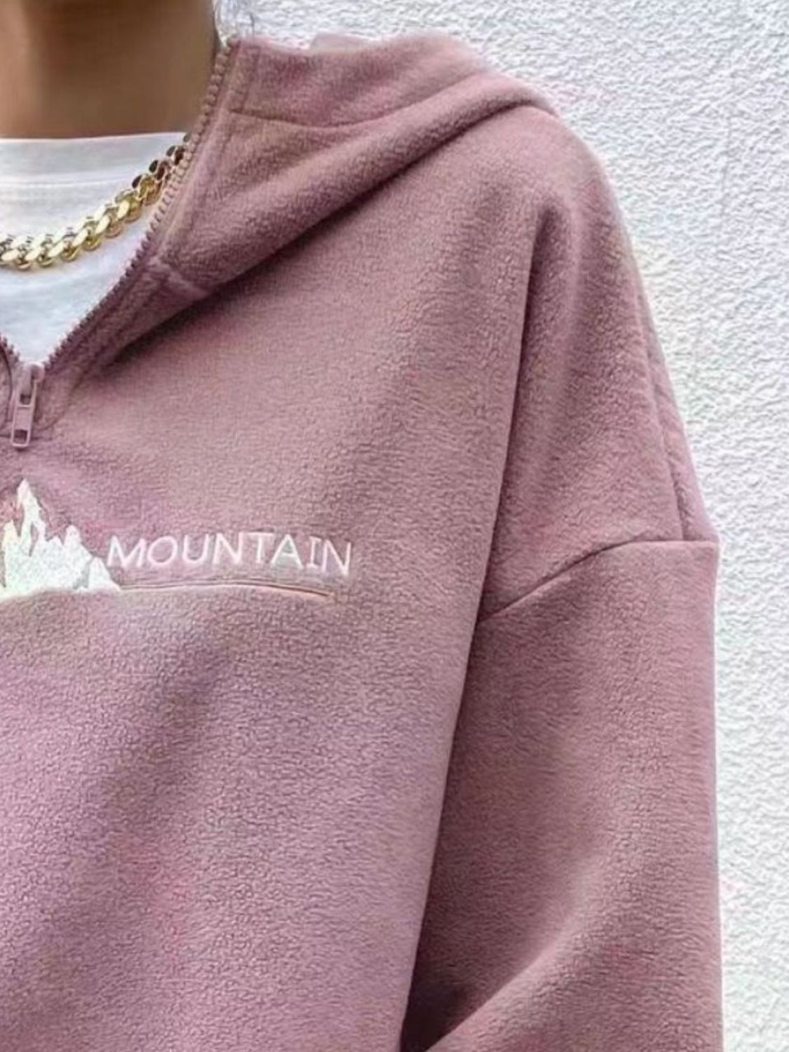 Pink-colored fleece sweatshirt with outdoor-inspired text.
