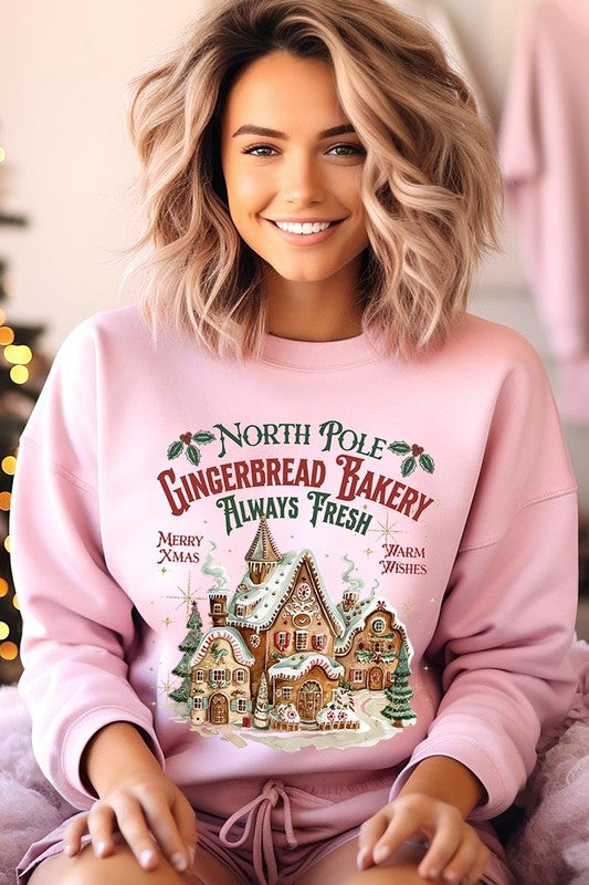 Cozy pink holiday sweatshirt featuring North Pole Gingerbread Bakery graphic.