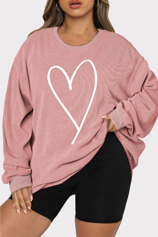 Plus-size woman in a pink heart graphic sweatshirt, perfect for casual wear