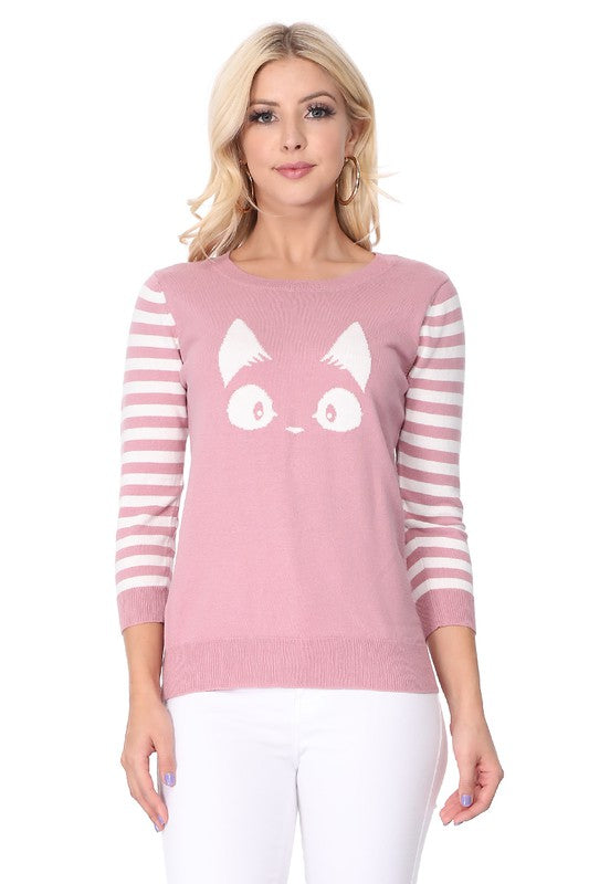 Woman wearing a pink sweater with a cute kitty face and striped sleeves.
