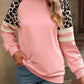 Relaxed-fit sweatshirt in pink with leopard print and striped sleeves for a chic casual look.
