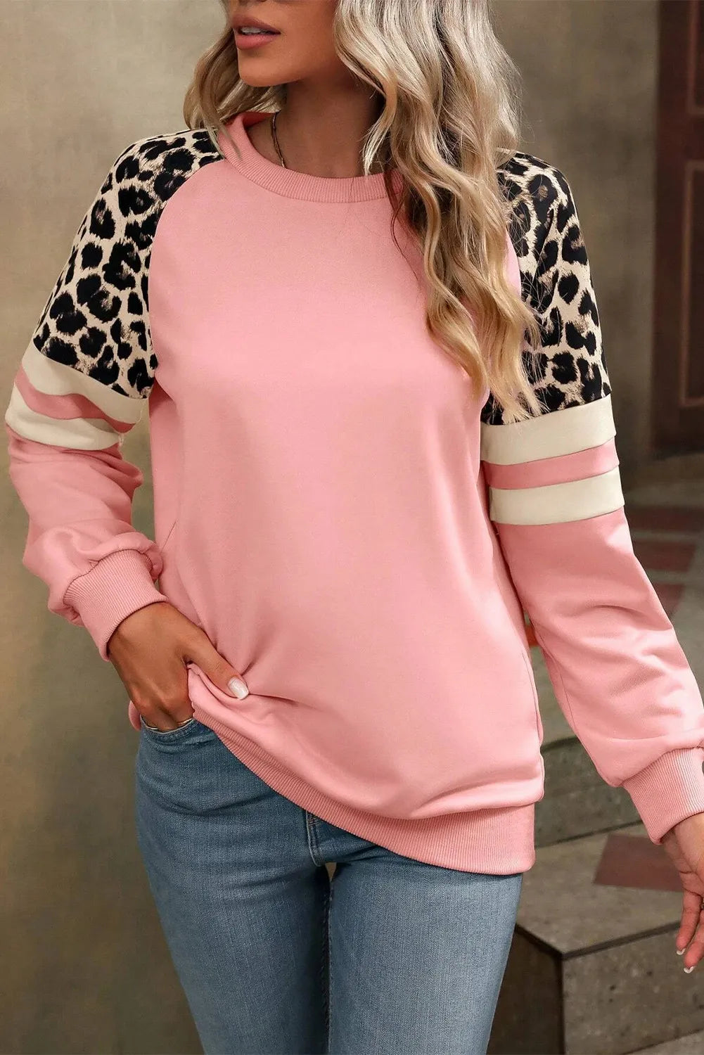 Relaxed-fit sweatshirt in pink with leopard print and striped sleeves for a chic casual look.
