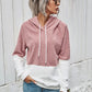 Front view of a pink sherpa hoodie with a white color block design.
