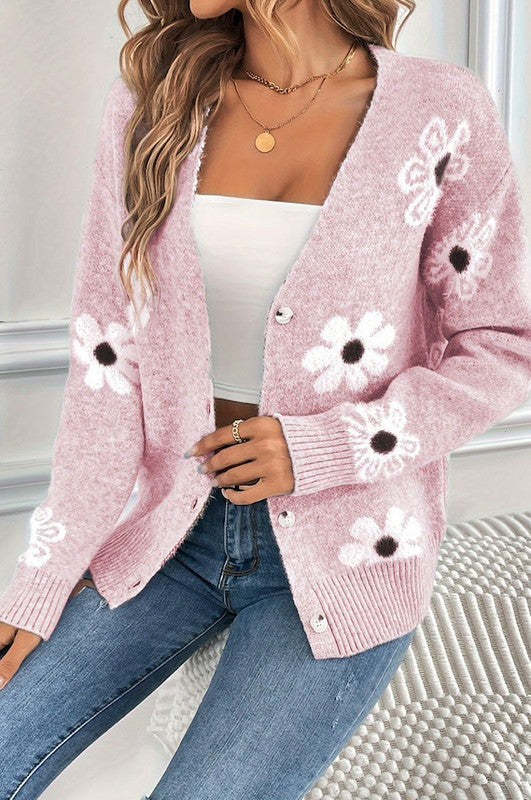 Pink cardigan featuring white floral designs, perfect for a feminine touch.