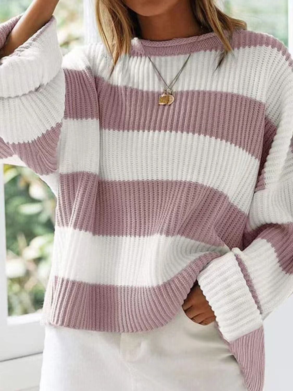 Retro-inspired pink striped sweater, ideal for layering in cooler weather.
