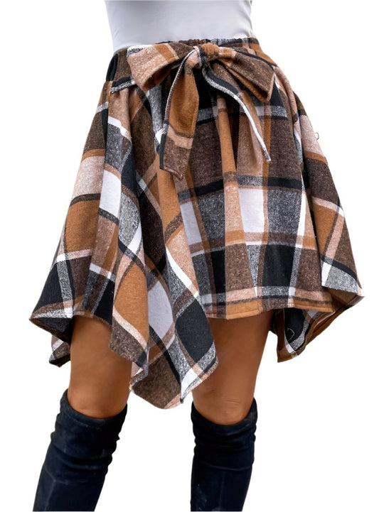 Caramel plaid skirt with handkerchief hem, paired with black knee-high boots.
