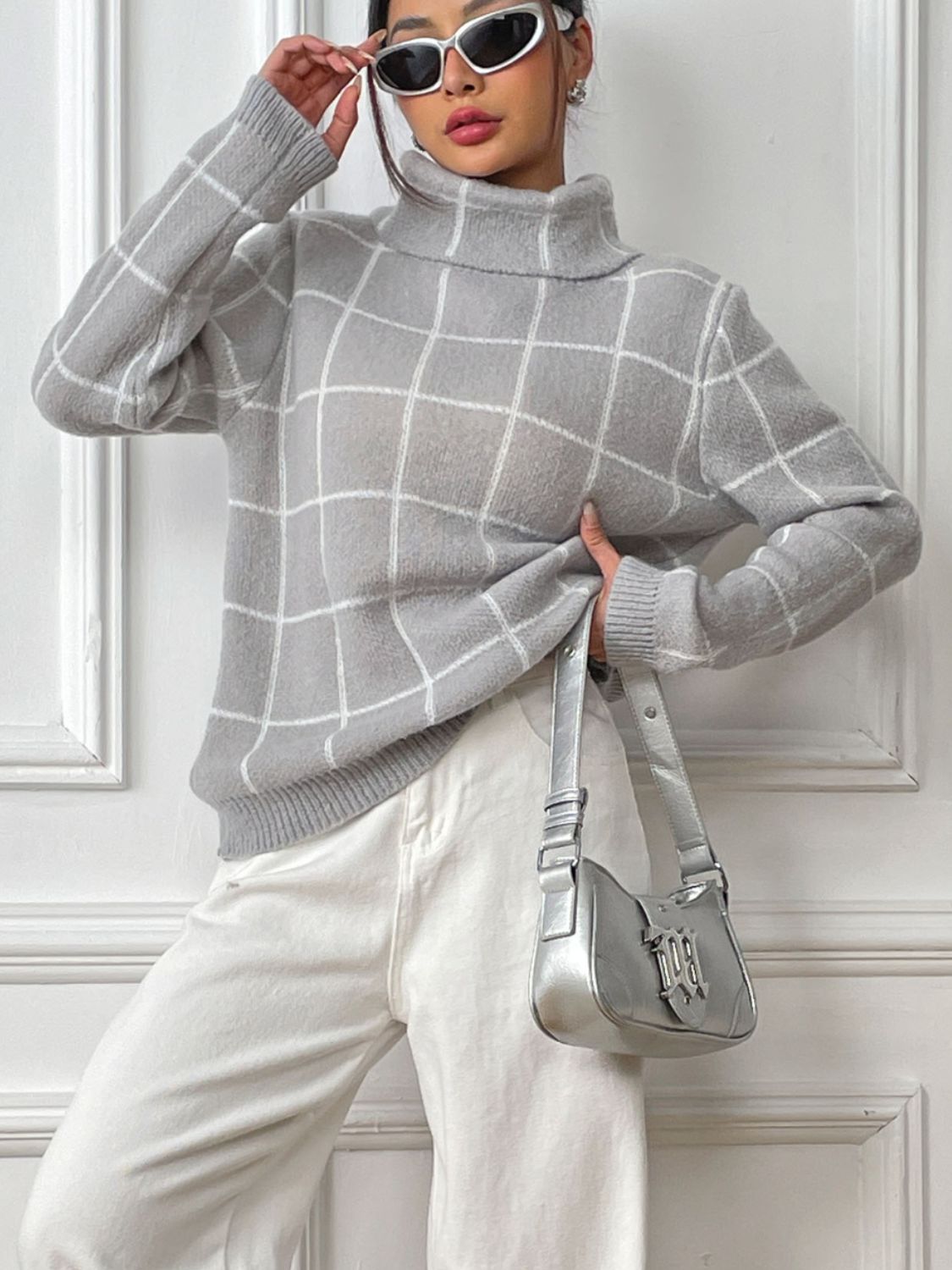 Woman in a relaxed gray plaid knit sweater with turtleneck