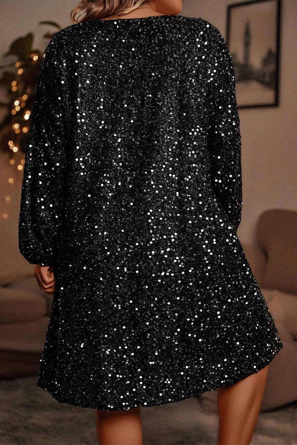 Back view of plus-size black sequin dress with flowy silhouette
