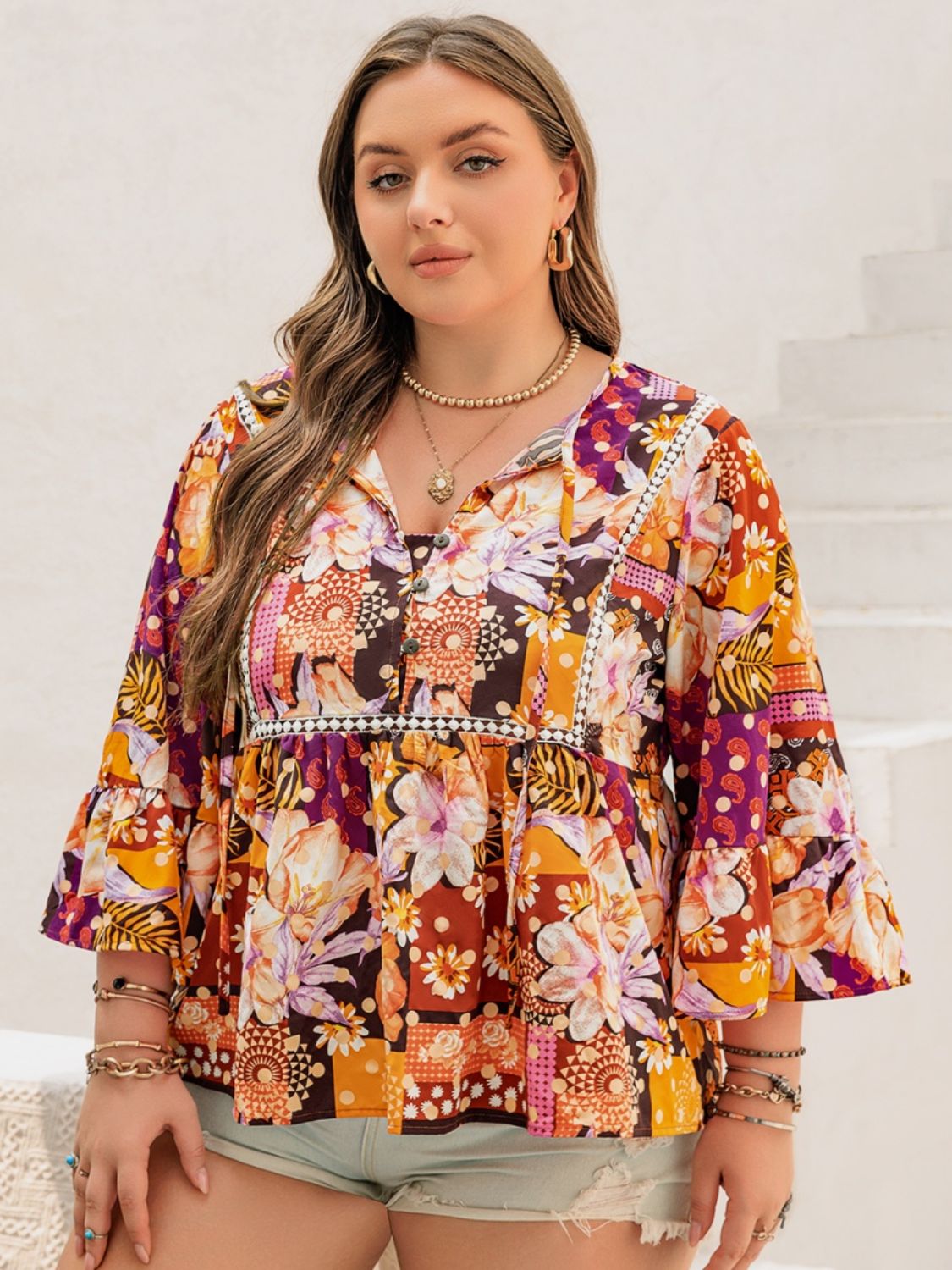 Close-up of floral and abstract print top with lace trim detail.
