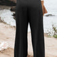 Black smocked high waist pants with flowy wide-leg fit for curves.