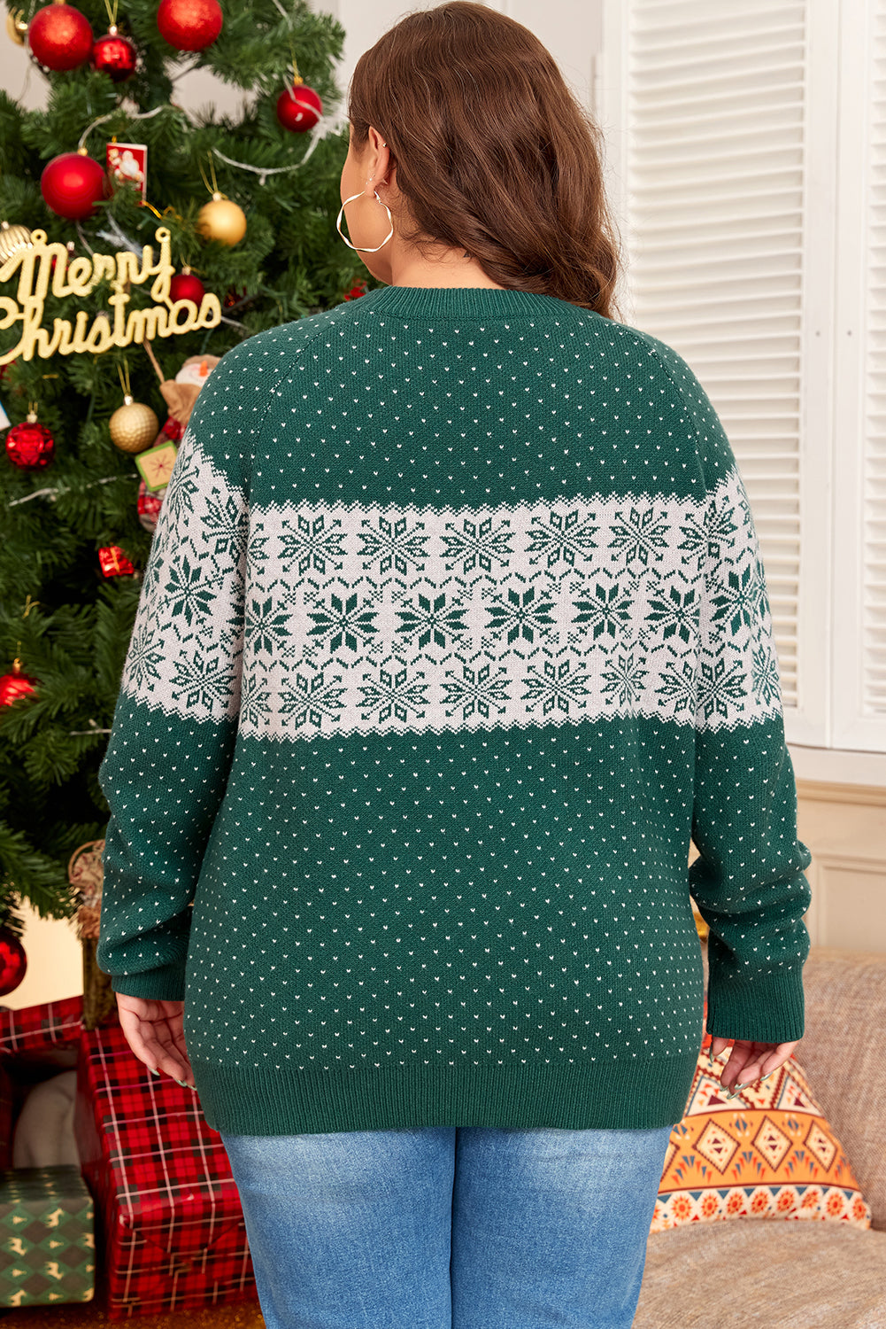 Plus-size green sweater featuring white snowflake design for winter.
