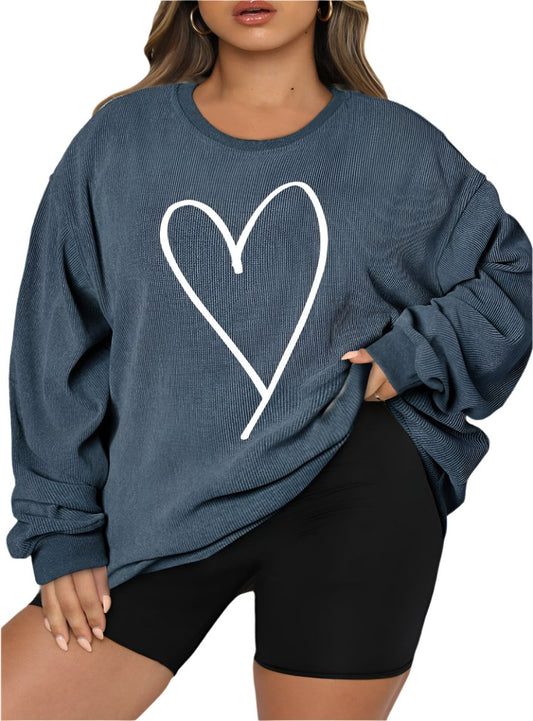 Plus-size woman wearing a teal oversized sweatshirt with a white heart graphic