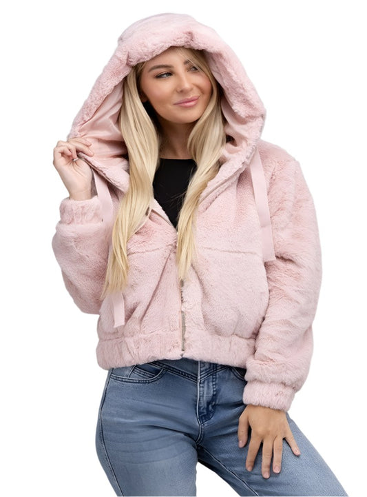 Woman in a plush pink faux fur hoodie with a hood, posing stylishly
