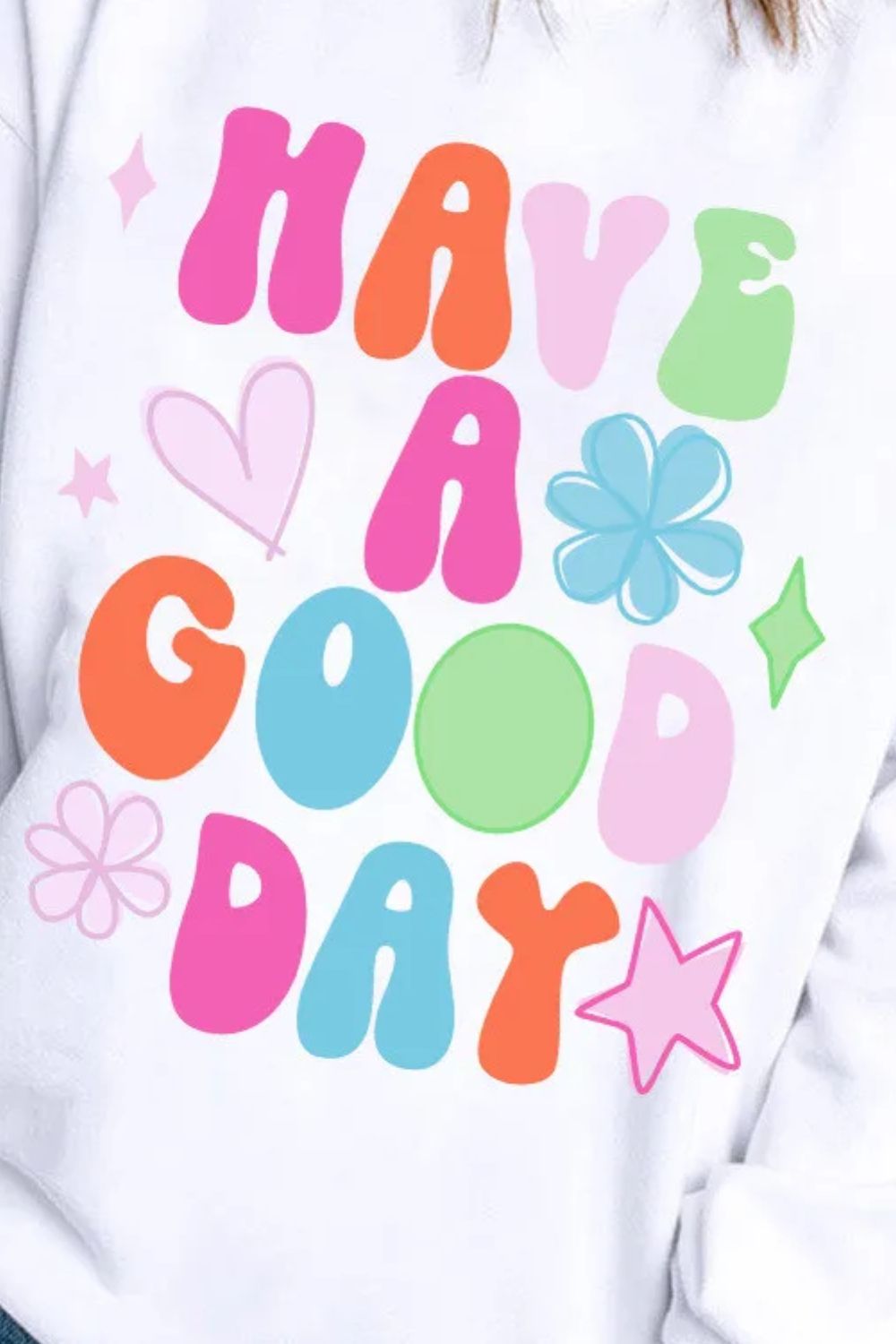 Close-up of cheerful "Have A Good Day" message on women’s pullover.
