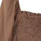 Close-up of the puff sleeves and square neckline on the smocked top.
