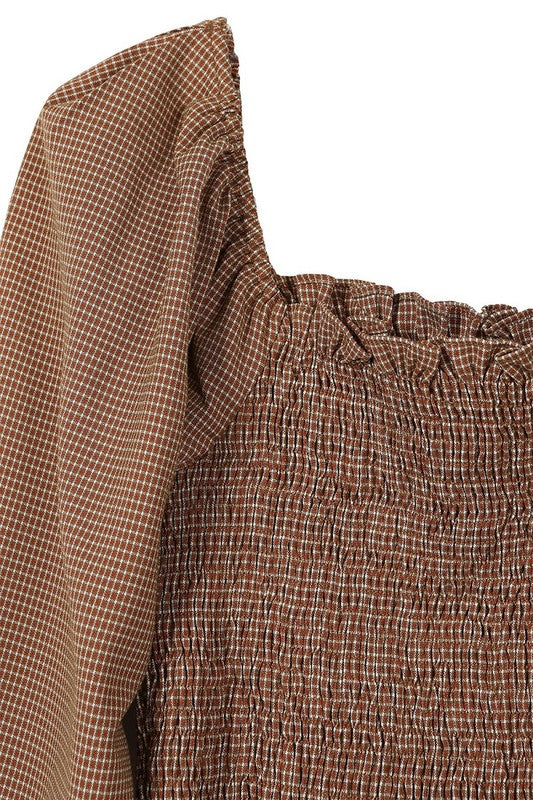 Close-up of the puff sleeves and square neckline on the smocked top.
