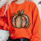 Orange pumpkin graphic sweatshirt styled for autumn
