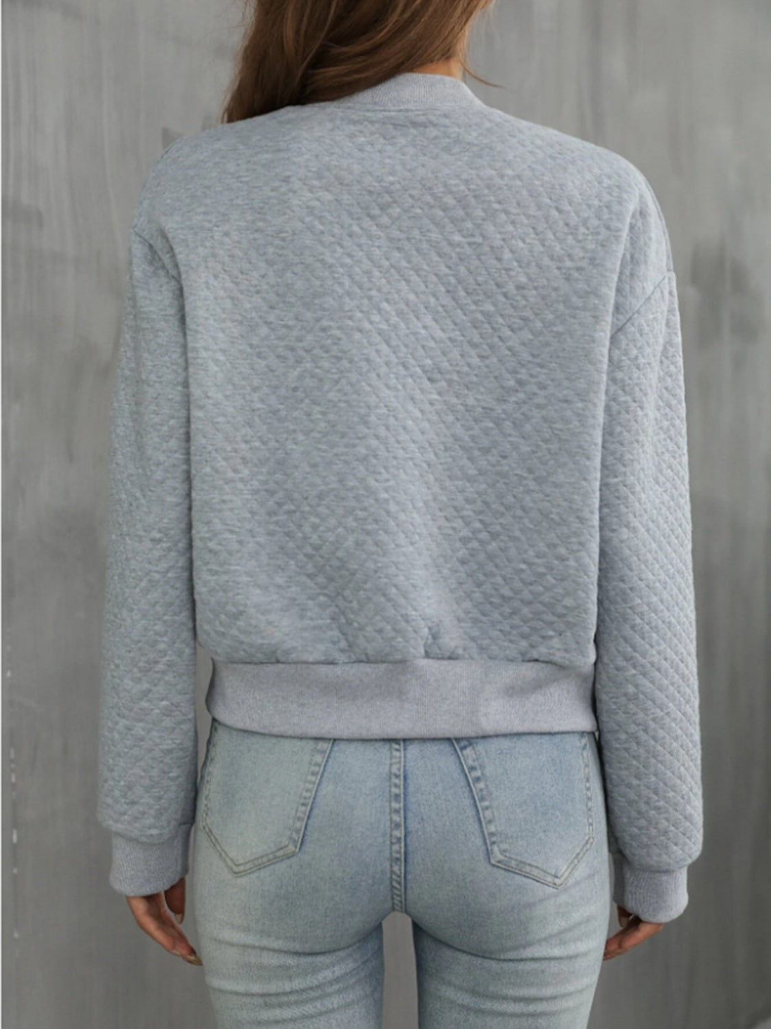 Back view of gray quilted bomber jacket, perfect for layering in cooler weather.