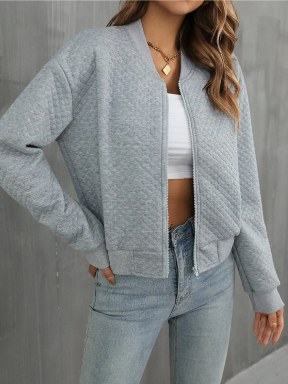 Front view of gray quilted bomber jacket, offering a neutral, easy-to-style option.
