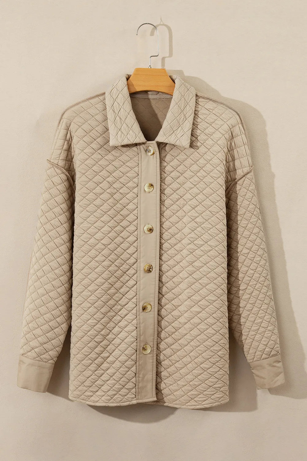 Back view of a quilted neutral oversized jacket.
