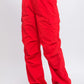 Red cargo pants featuring adjustable ankle fastenings and relaxed silhouette.
