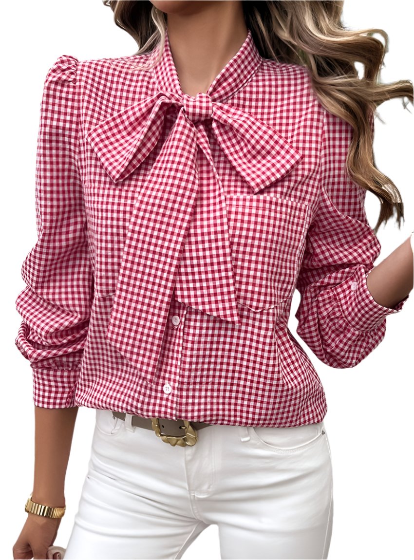 Woman wearing a red gingham bow tie blouse with puff sleeves and white pants.
