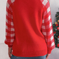 Cozy red holiday sweater with a reindeer graphic and plaid sleeves, perfect for Christmas festivities.