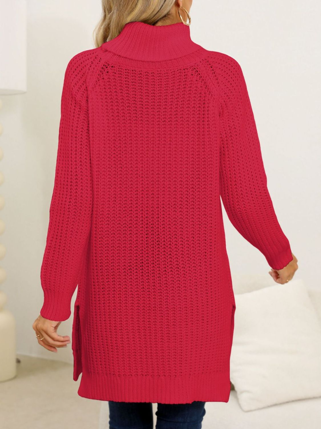 Woman in a red longline sweater with a cozy turtleneck design.
