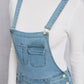 Slightly stretchy distressed denim light wash overalls styled for casual daytime wear.
