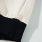 A relaxed-fit textured beige pullover with black trim, perfect for layering and fall fashion.

