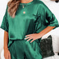 Relaxed green satin loungewear set styled on a model.
