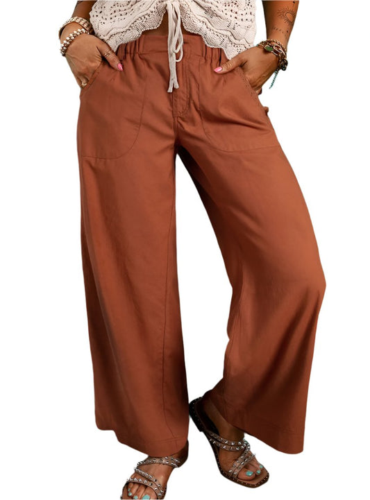 Relaxed wide-leg drawstring pants in rust color, front view showing elastic waistband.
