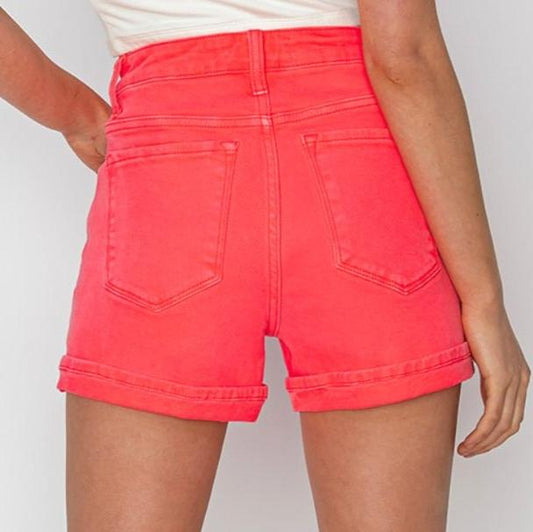 Back view of RISEN high rise cuffed denim shorts in neon coral.