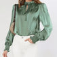 Green lantern sleeve blouse styled with layered jewelry for a trendy vibe.
