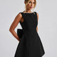 Romantic black A-line dress adorned with pearl trim and a statement bow.