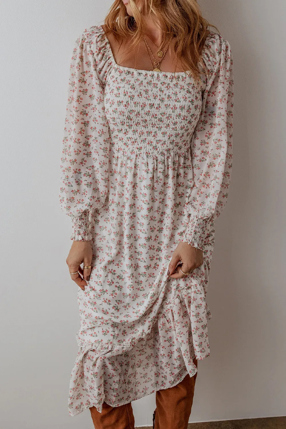 Romantic long sleeve floral midi dress styled with knee-high boots.
