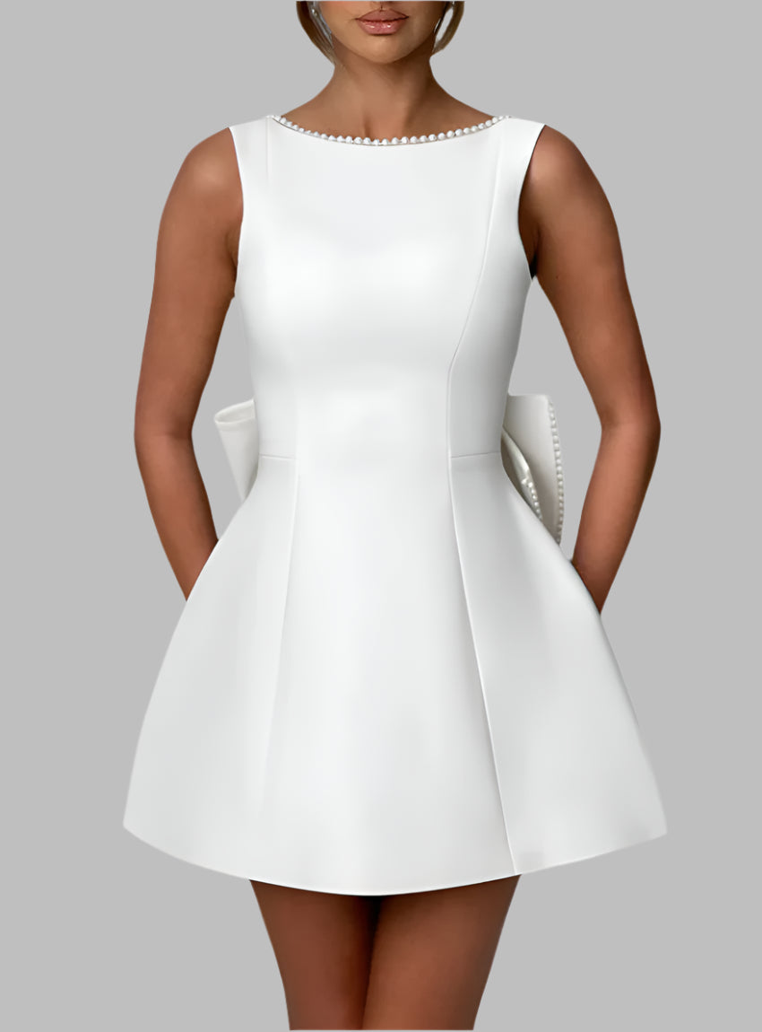 Feminine white dress with oversized bow and tailored silhouette
