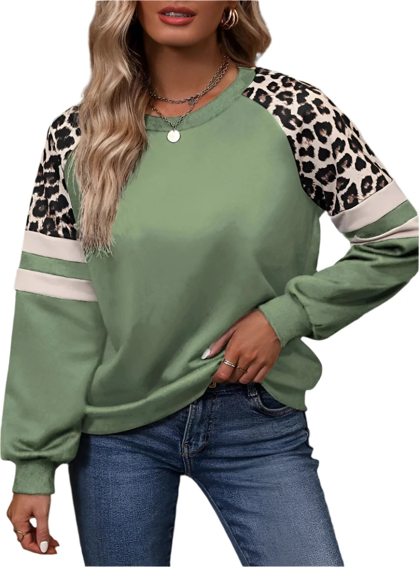 Sage green pullover with leopard print accents and contrast stripes, styled with jeans.
