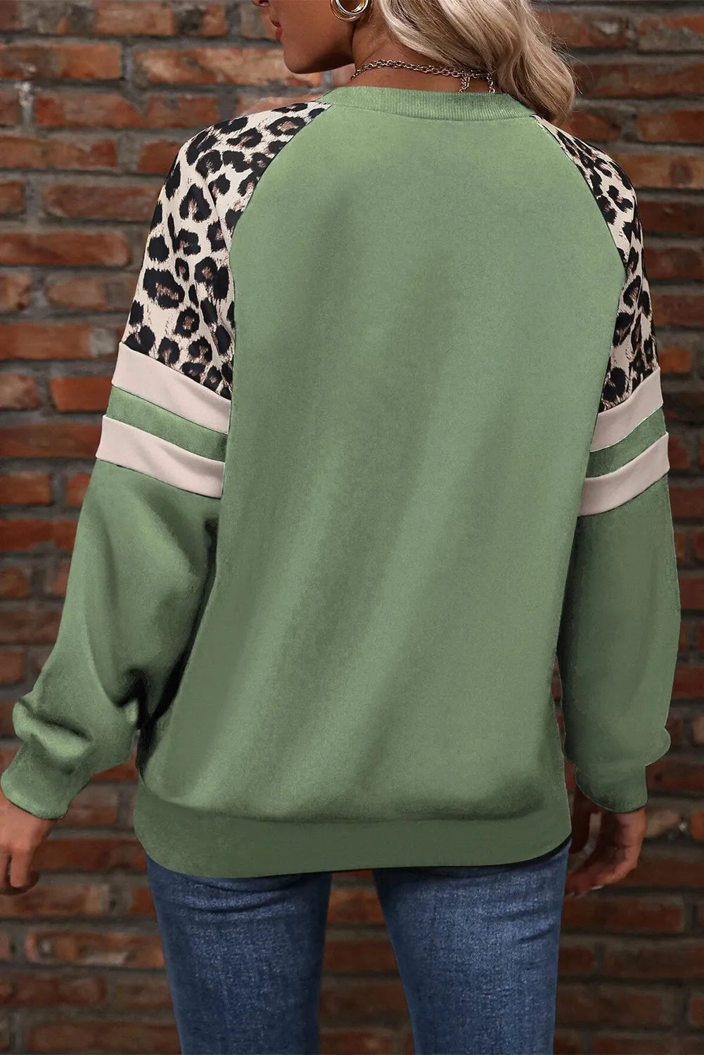 Soft and trendy sage green sweatshirt with a bold leopard-print shoulder pattern.
