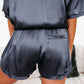 Closeup of satin navy lounge set showing soft, luxurious fabric and design.
