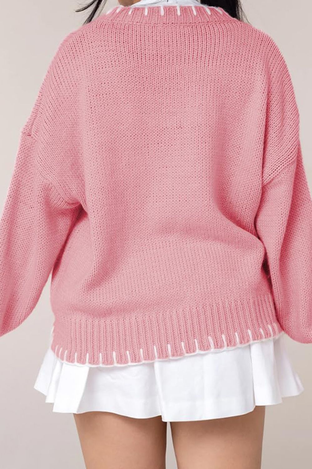 Side view of a pink bow-knot knit sweater, perfect for staying cozy and stylish during winter.

