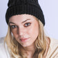 Soft black cable knit beanie with luxurious fur pom accent

